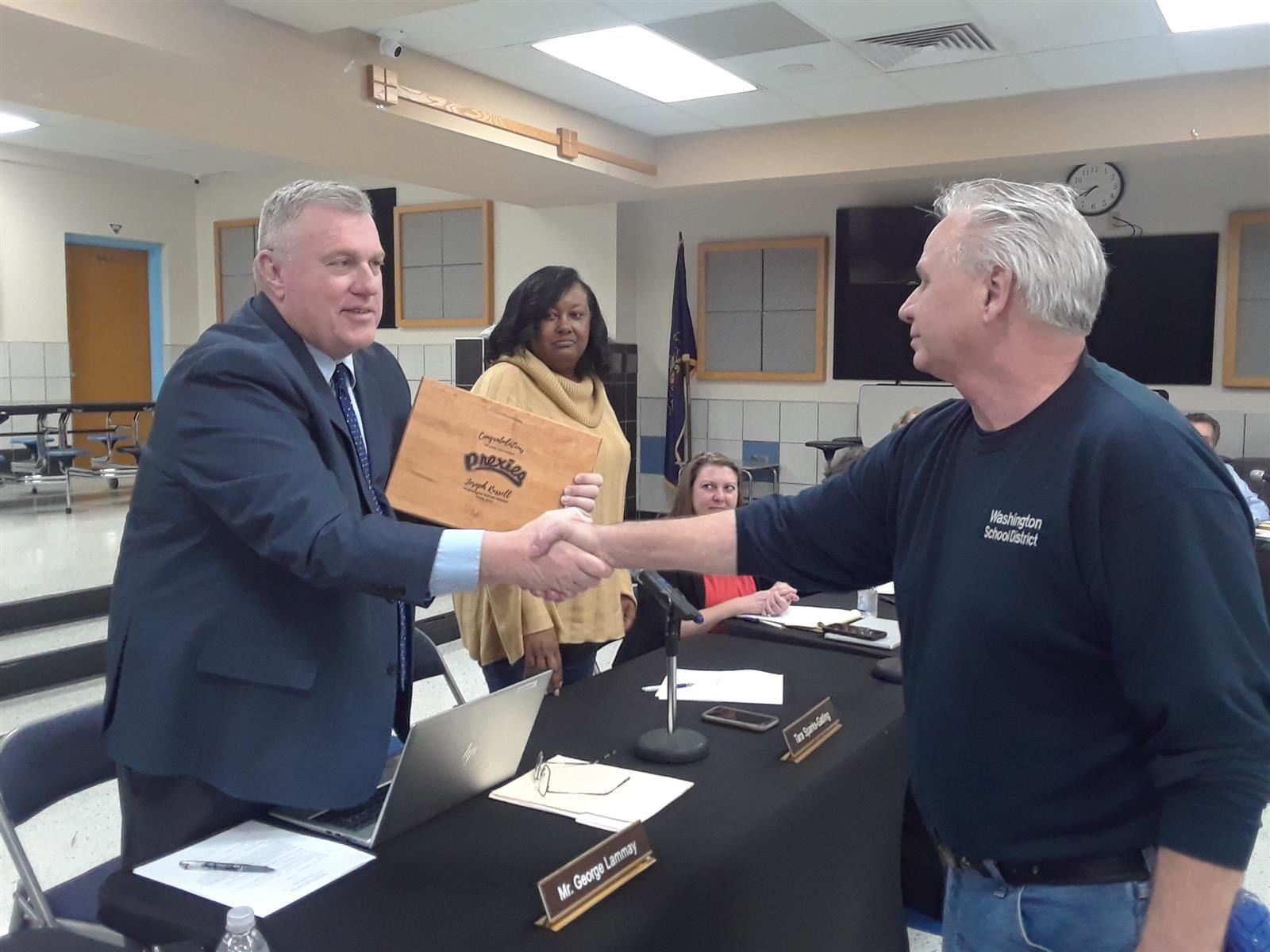 Employee Joe Russell shaking George Lammay's hand